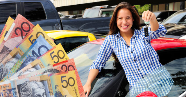 Female brunette holding her keys up as she is selling her car and receiving money.