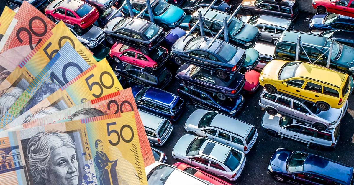 Car wrecking yard with cars stacked on top of each other and money being offered.