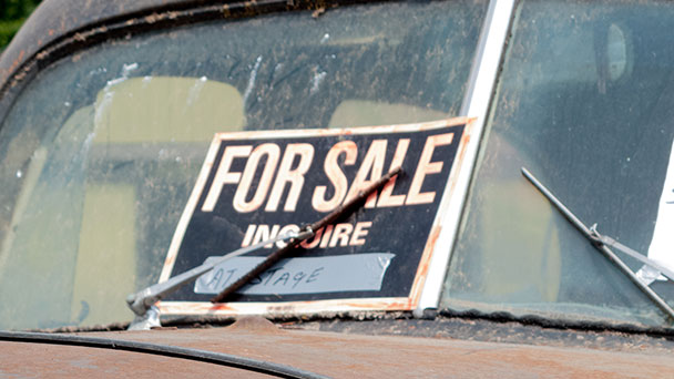 For sale sign on windscreen of old rust bucket or a car.